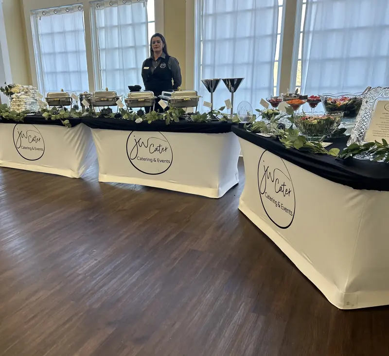 Long buffet line with JW Cater table covers and greenery