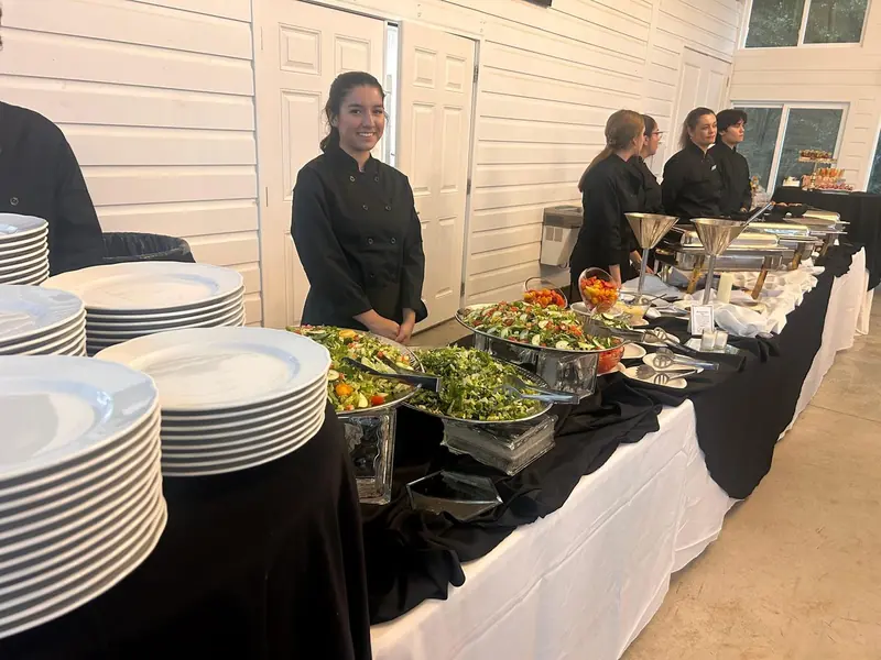 JW Cater team member behind a salad buffet