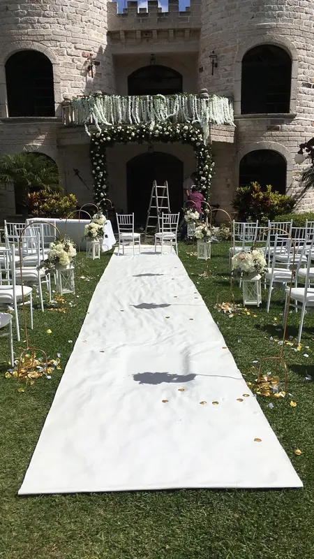 White aisle runner leading to a stone castle venue