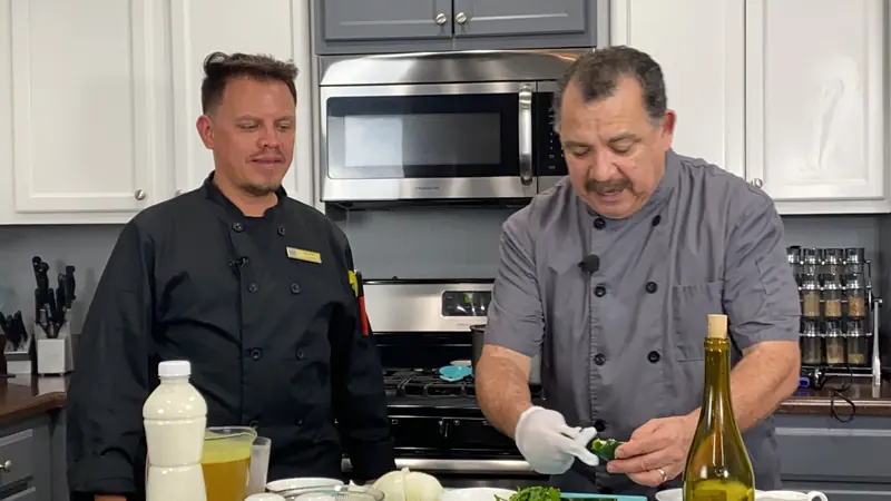 Chef John William and a JW Cater chef cooking in a kitchen