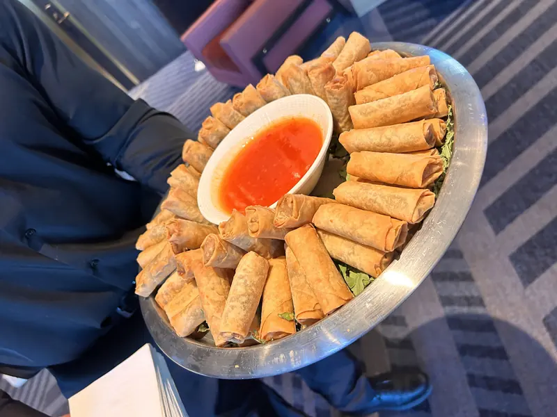 Egg rolls around a bowl of sweet chili sauce