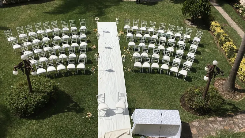 Garden ceremony seating with a white aisle runner