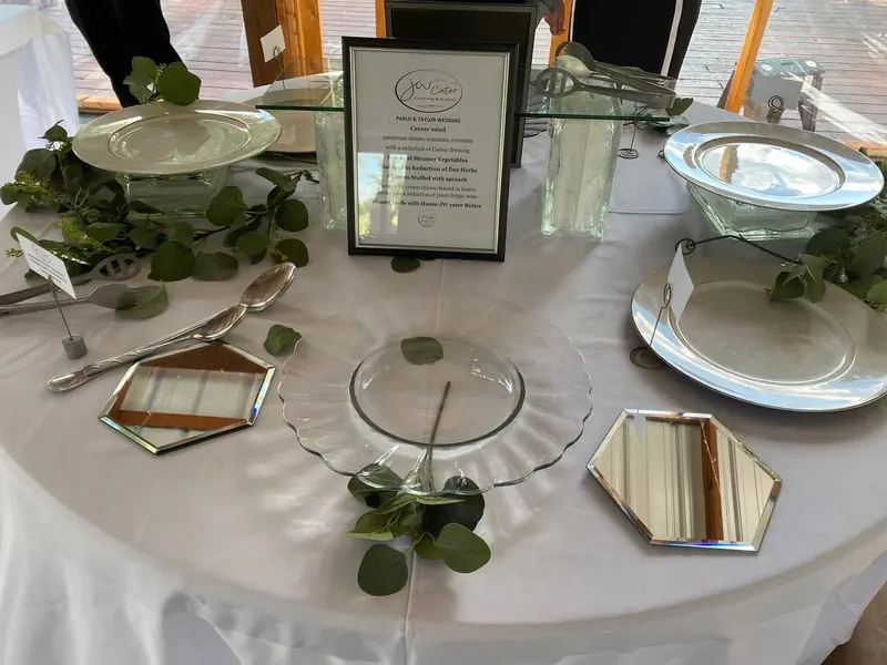 Table set with glass chargers, place cards and eucalyptus