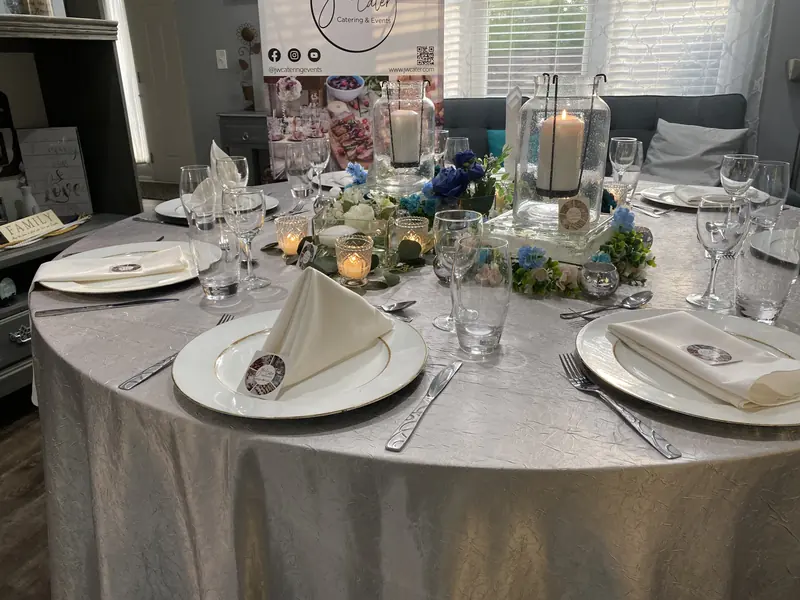 Round table in gray linen with blue florals and candles