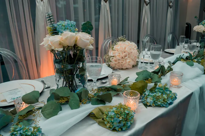 Wedding head table with white roses, hydrangeas and candlelight