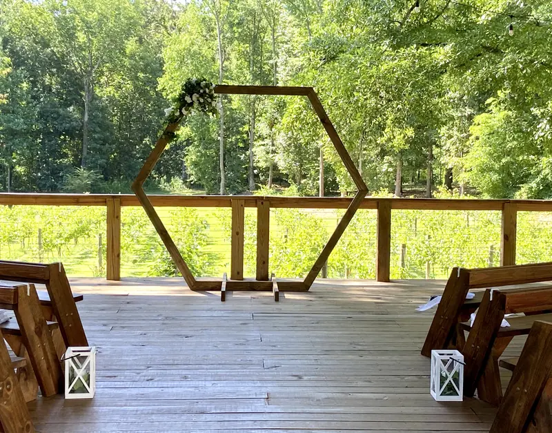 Wooden hexagon arch on a deck overlooking the woods