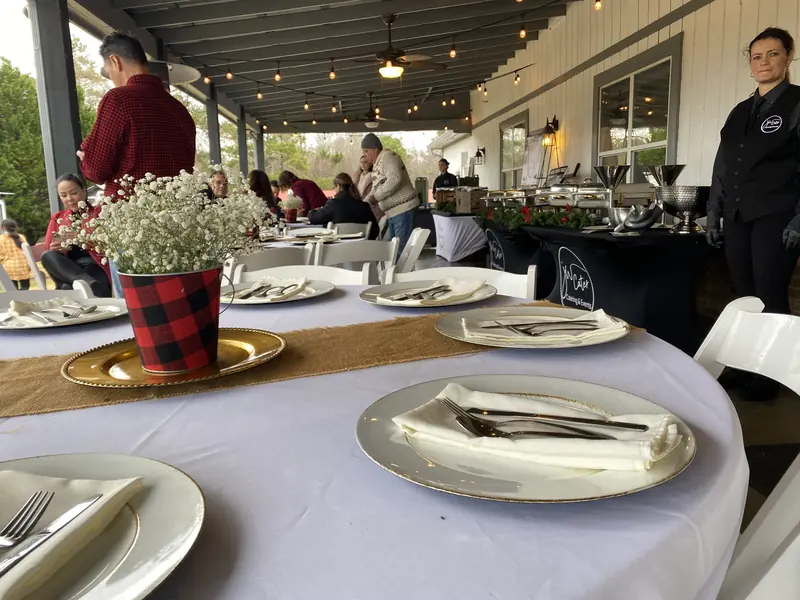 Holiday table with gold chargers and plaid centerpieces
