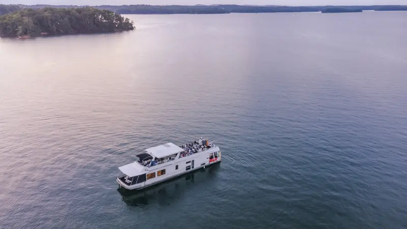 Aerial view of a houseboat wedding party on a lake at sunset