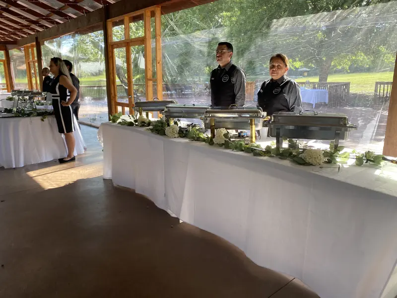 JW Cater staff ready behind a pavilion buffet