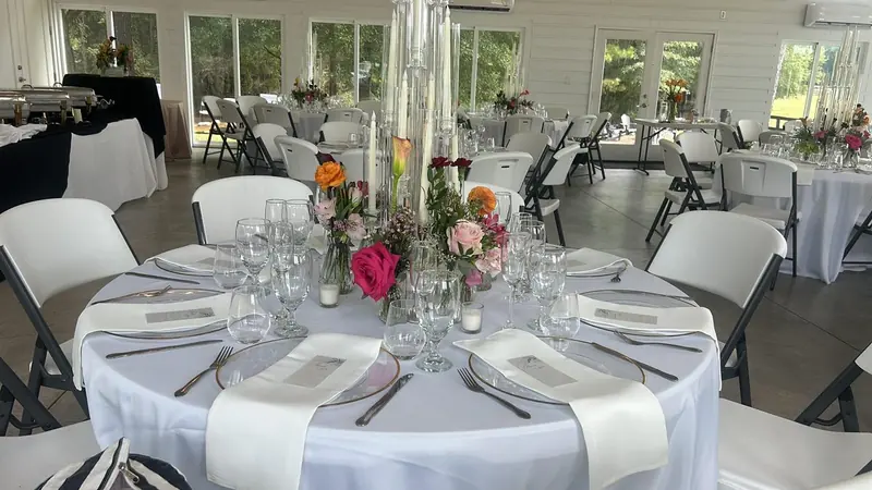 Round table with gold-rim chargers and bright floral centerpieces