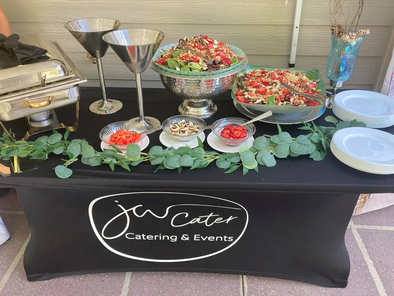 Salad station on black linen with a framed menu