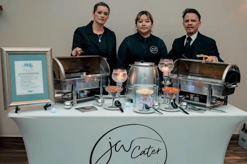 Johana, John William and a team member behind a buffet station