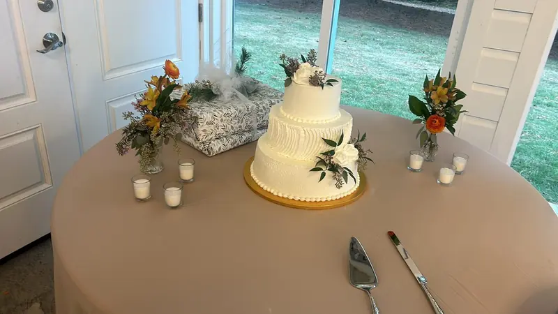 Three-tier white wedding cake with fresh flowers