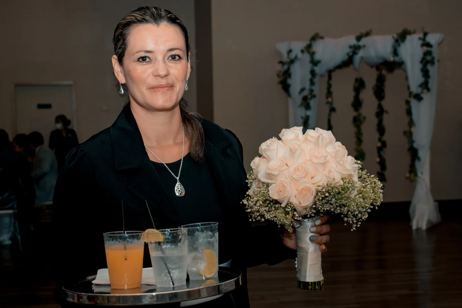 JW Cater team member carrying a tray of drinks at a wedding reception